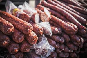 An outdoor stall with a bunch of homemade sausages for sale photo