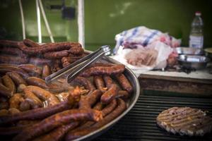 An outdoor food stall selling grilled homemade sausages photo