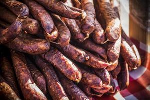 An outdoor stall with a bunch of homemade sausages for sale photo