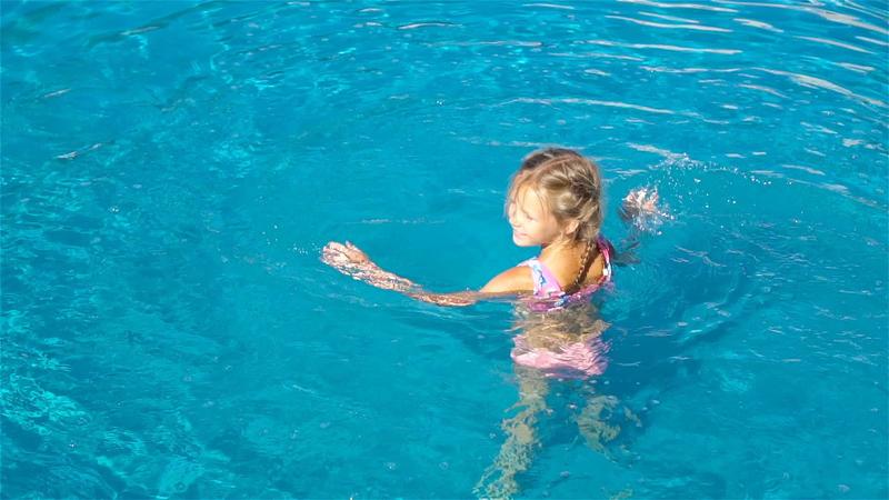 Adorable little girl in outdoor swimming pool 20001109 Stock Video at Vecteezy
