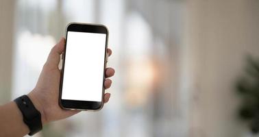 Cerrar la mano de la mujer usando un teléfono inteligente con pantalla en blanco en la cafetería cafetería. foto