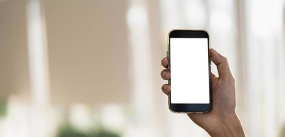 Cerrar la mano de la mujer usando un teléfono inteligente con pantalla en blanco en la cafetería cafetería. foto