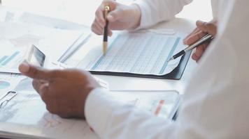 Financial analysts analyze business financial reports on a digital tablet planning investment project during a discussion at a meeting of corporate showing the results of their successful teamwork. video