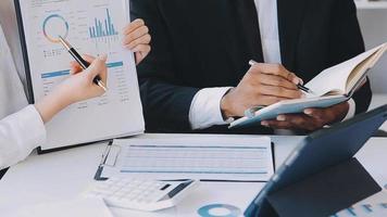 Financial analysts analyze business financial reports on a digital tablet planning investment project during a discussion at a meeting of corporate showing the results of their successful teamwork. video