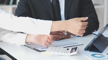 Financial analysts analyze business financial reports on a digital tablet planning investment project during a discussion at a meeting of corporate showing the results of their successful teamwork. video