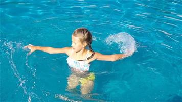 Adorable little girl in outdoor swimming pool video