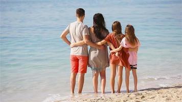 joven familia de cuatro en vacaciones en la playa video