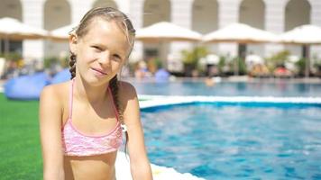 belle petite fille s'amusant près d'une piscine extérieure video