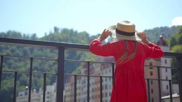 niña con sombrero en el terraplén de un río de montaña en una ciudad europea. video