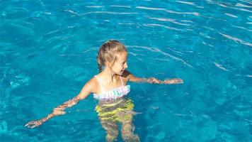 Adorable little girl in outdoor swimming pool video