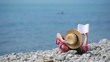 giovane donna lettura libro durante tropicale bianca spiaggia video