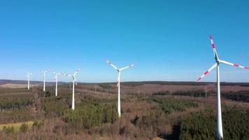 Video of wind turbine field in Germany with rotating wind turbines during daytime with blue sky