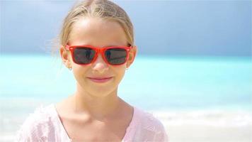 adorabile poco ragazza su il spiaggia avendo divertimento su caraibico isola. video