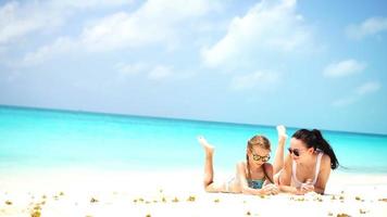 kleines entzückendes Mädchen und junge Mutter am tropischen Strand video