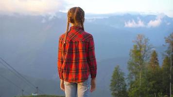 bellissimo contento poco ragazza nel montagne nel il sfondo di nebbia video