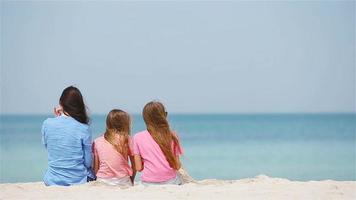 madre e hijas pequeñas haciendo castillos de arena en la playa tropical video