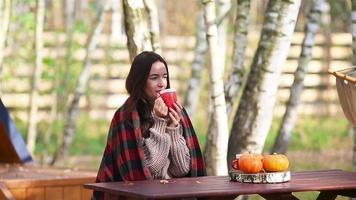mulher desfrutando dentro outono dia enquanto bebendo café video