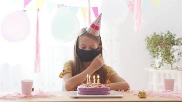 caucasiano menina olhando às aniversário arco Iris bolo. festivo colorida fundo com balões. aniversário festa e desejos conceito. video