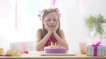 Kaukasisches Mädchen trägt an ihrem Geburtstag eine Maske. festlicher bunter hintergrund mit luftballons. geburtstagsfeier und wunschkonzept. video