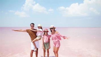 Family walk on a pink salt lake on a sunny summer day. video