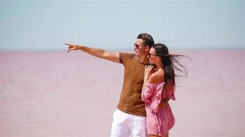 Family walk on a pink salt lake on a sunny summer day. video