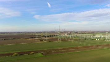 Drone video of a flight along a power line towards a substation during daytime