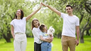 adorable famille dans un jardin de cerisiers en fleurs le beau jour du printemps video