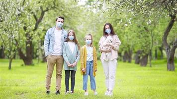 Adorable family in blooming cherry garden in masks video