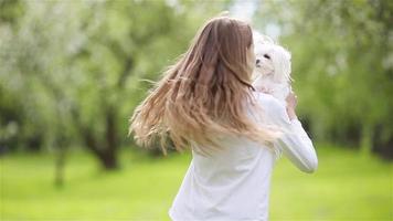 Little smiling girls playing and hugging puppy in the park video