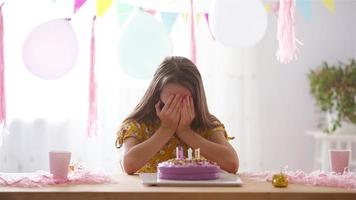 niña caucásica usa una máscara en su cumpleaños. fondo colorido festivo con globos. concepto de fiesta y deseos de cumpleaños. video