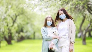 familia de madre e hija en el floreciente jardín de cerezos con máscaras video