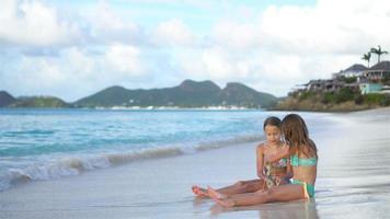 Adorable little girls relaxing on the beach video