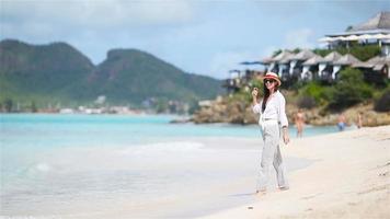 mujer hermosa joven divirtiéndose en la costa tropical. video
