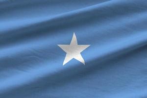 Somalia flag with big folds waving close up under the studio light indoors. The official symbols and colors in banner photo