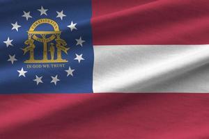Georgia US state flag with big folds waving close up under the studio light indoors. The official symbols and colors in banner photo