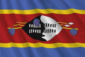 Swaziland flag with big folds waving close up under the studio light indoors. The official symbols and colors in banner photo