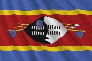 Swaziland flag with big folds waving close up under the studio light indoors. The official symbols and colors in banner photo