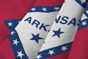 Arkansas US state flag with big folds waving close up under the studio light indoors. The official symbols and colors in banner photo