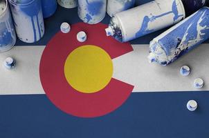 Colorado US state flag and few used aerosol spray cans for graffiti painting. Street art culture concept photo