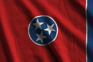 Tennessee US state flag with big folds waving close up under the studio light indoors. The official symbols and colors in banner photo