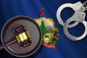 Vermont US state flag with judge mallet and handcuffs in dark room. Concept of criminal and punishment photo