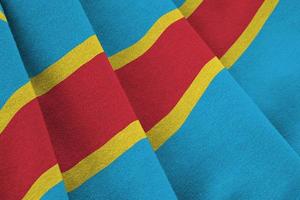 Democratic Republic of the Congo flag with big folds waving close up under the studio light indoors. The official symbols and colors in banner photo