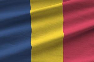 Chad flag with big folds waving close up under the studio light indoors. The official symbols and colors in banner photo