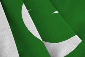 Pakistan flag with big folds waving close up under the studio light indoors. The official symbols and colors in banner photo