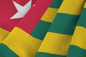 Togo flag with big folds waving close up under the studio light indoors. The official symbols and colors in banner photo