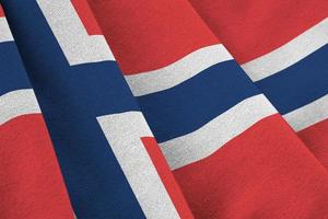 Norway flag with big folds waving close up under the studio light indoors. The official symbols and colors in banner photo