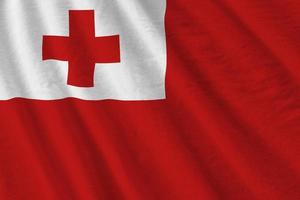 Tonga flag with big folds waving close up under the studio light indoors. The official symbols and colors in banner photo