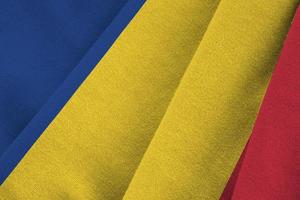 Romania flag with big folds waving close up under the studio light indoors. The official symbols and colors in banner photo