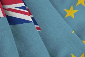 Tuvalu flag with big folds waving close up under the studio light indoors. The official symbols and colors in banner photo