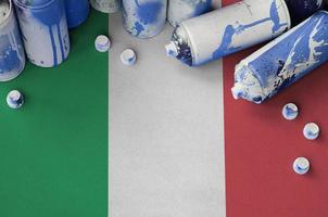 Italy flag and few used aerosol spray cans for graffiti painting. Street art culture concept photo